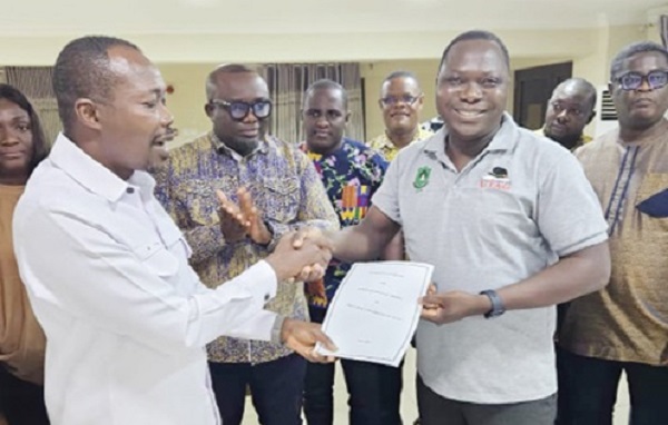 Benjamin Arthur (left), Chief Executive of FWSC, handing over the conditions of service to Prof. Mamudu Akudugu, UTAG National President